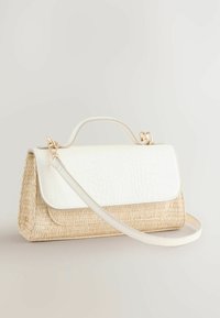 Borsa in paglia intrecciata con una patta bianca in pelle sintetica a motivo coccodrillo, dotata di manico superiore e tracolla removibile. Dettagli in hardware dorato.