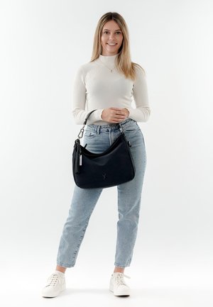 Borsa a spalla in pelle nera con forma curvata, texture morbida e hardware in argento. Presenta una nappina e il logo sul davanti.