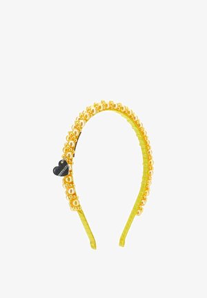 Żółta opaska na głowę ozdobiona skupiskami złotych pereł i małym czarnym serduszkowym zawieszonym po jednej stronie.