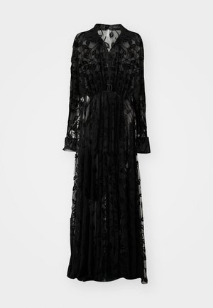 Vestido maxi negro transparente con bordado floral, mangas largas, escote alto, cintura ajustada y una silueta fluida.