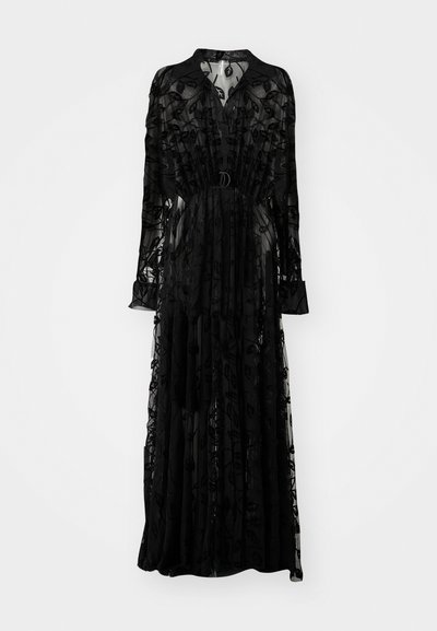 Robe maxi noire transparente ornée de broderies florales, à manches longues, à encolure haute, taille cintrée et silhouette fluide.