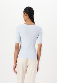 Lichtblauw fitted top met korte mouwen en een ronde halslijn, met een gladde textuur en een slanke silhouet.