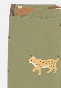 Olivengrüne Baumwollleggings mit verspielten Tiermotiven, darunter ein gefleckter Luchs, mit einer glatten Textur und einem elastischen Bund.