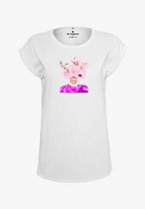 Weißes Baumwoll-T-Shirt mit aufgerollten Ärmeln. Das zentrale Grafikmotiv zeigt ein Gesicht, das von rosa Blumen verdeckt wird, und ein lila Blumenmuster im Nackenbereich.