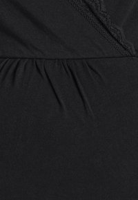 Μαύρο φόρεμα από απαλό ύφασμα με σούρες στη μέση, περίτεχνη δαντέλα κατά μήκος του ντεκολτέ και λείο, υφασμάτ�ινο φινίρισμα.