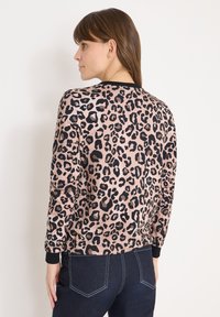 Leopardprint sweater van zachte stof met een aansluitende pasvorm, geribbelde zwarte boorden en een ronde halslijn. Achteraanzicht toont het ontwerpdetail.
