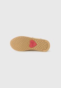 Semelle en caoutchouc avec un motif hexagonal. Couleur beige avec un accent en forme de cœur rouge portant l'inscription "AMOUR". Texturé pour l'adhérence.