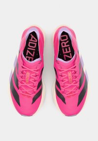 Pár jasnoružových športových topánok s čiernymi pásmi, ružovými šnúrkami, bielymi podrážkami a "ADIZERO" vytlačeným vo vnútri a na jazýčku.