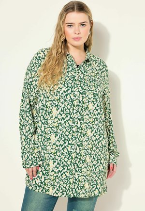 Groene bloempatronen shirt met een relaxte pasvorm, voorzien van grote witte en gele bloemen, lange mouwen, een knoopsluiting aan de voorkant en een borstzak.