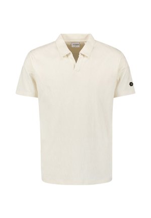 Short-sleeve polo in cream with a textured pattern, featuring a V-neck and a black hexagonal logo patch on the left sleeve.