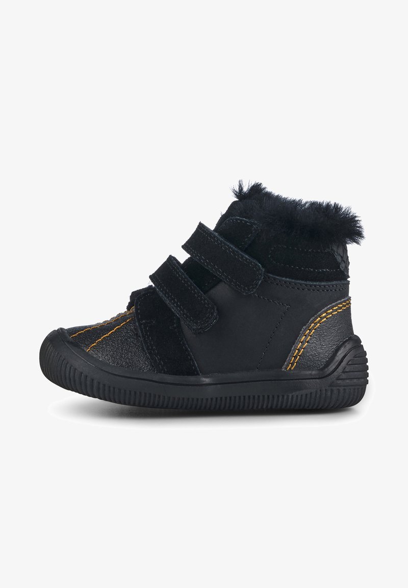 Bottines noires avec deux bandes Velcro ; les matériaux incluent du cuir lisse et du daim ; elles présentent des coutures jaunes et une semelle en caoutchouc texturée.
