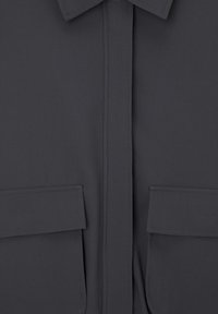 Mørkegrå skjorte med knaplukning, der har en spidse krave, to forlommer og en glat stofkvalitet med minimal tekstur og detaljer.