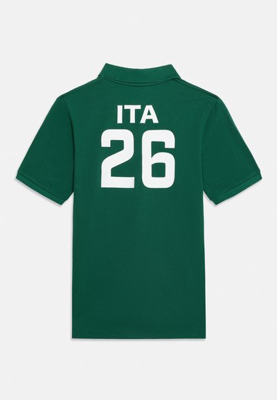 Σκούρο πράσινο πόλο με κοντά μανίκια, λευκό «ITA» και αριθμό «26» τυπωμένο στην πλάτη.