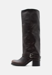 Σκούρο καφέ δερμάτινη μπότα μέχρι το γόνατο με στρογγυλεμένη μύτη, χαμηλό χοντρό τακούνι και διακοσμητικό λουράκι με ασημένια αγκράφα κοντά στον αστράγαλο.