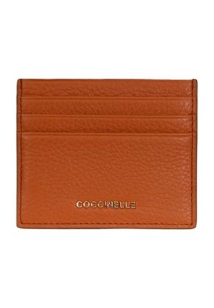 Portacarte piccolo in pelle marrone con quattro fessure orizzontali e logo dorato "COCCINELLE" posizionato al centro in basso.