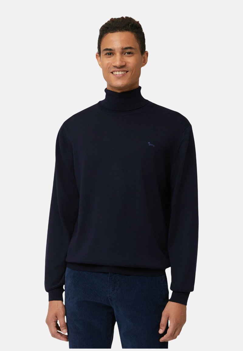Maglione a collo alto blu navy in tessuto lavorato a maglia liscia con polsini e orlo a coste. Piccolo logo sul petto, abbinato a pantaloni scuri.