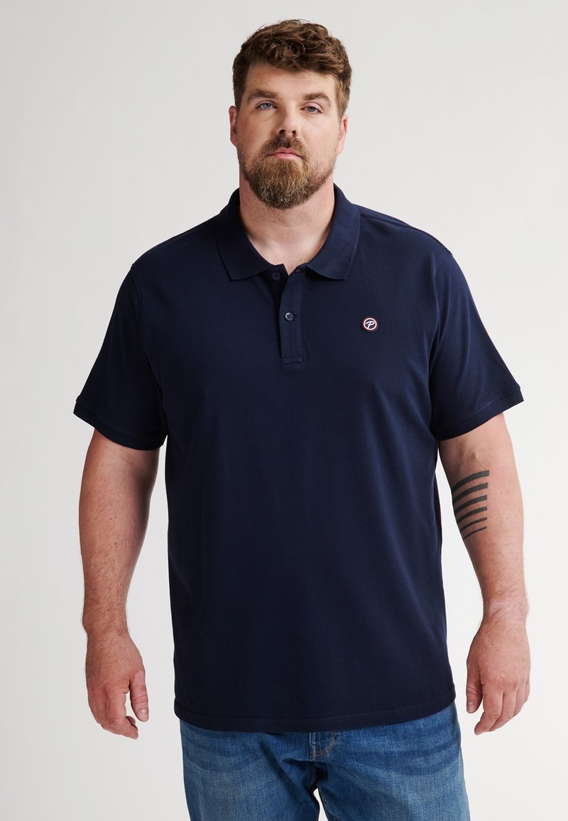Marineblauwe polo-shirt van een zachte stof, met een drieknoopsluiting, korte mouwen en een klein logo op de borst.