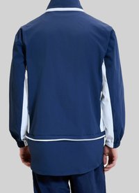 Granatowa kurtka z białymi akcentami, z długimi rękawami, elastycznymi mankietami i wysokim kołnierzem. Posiada zamek błyskawiczny oraz luźny krój.