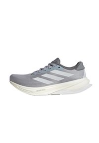 Chaussure de course grise avec une tige texturée, accents gris clair, semelle intermédiaire blanche et trois rayures proéminentes sur le côté. Design léger.