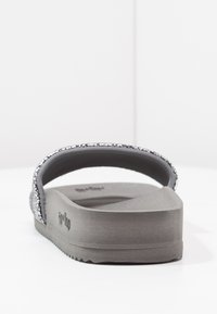 Gray flip-flop with a textured, cushioned sole and a sparkling strap. Features a simple design and a thick heel for added support.