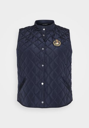 Gilet matelassé bleu marine avec un col haut, des boutons-pression et un emblème brodé sur la poitrine. Comprend deux poches latérales.