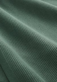 Zielony tkanina o fakturze prążków z pionowymi liniami, prezentująca miękkość i gładkie, matowe wykończenie. Odpowiednia do różnych zastosowań tekstylnych.