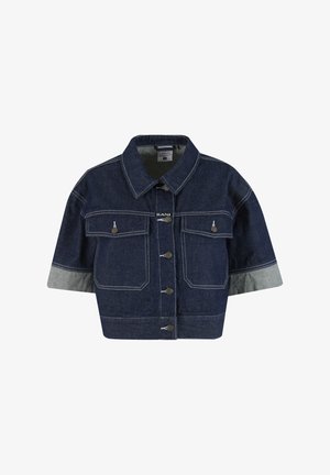 Veste en jean courte bleu foncé avec manches courtes, fermeture à boutons sur le devant, deux poches poitrine et poignets de manches gris clair contrastants.