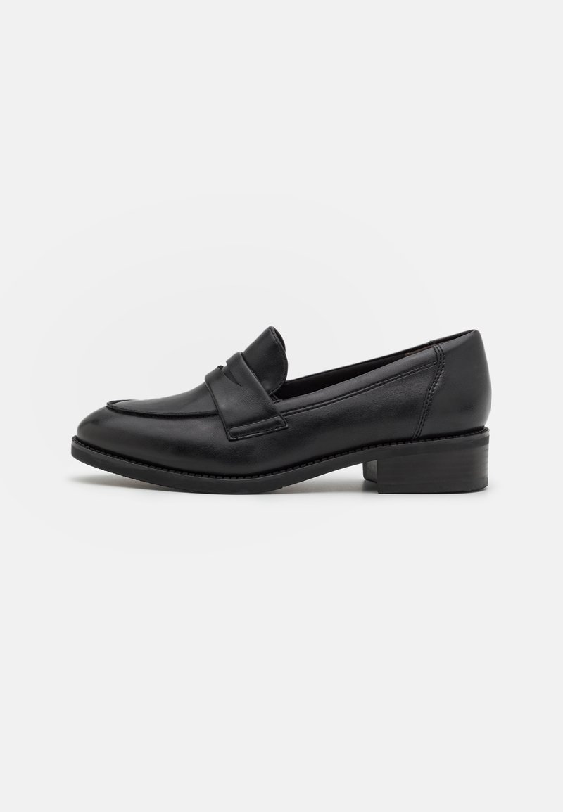 Mocassin en cuir noir avec un petit talon carré et une bride sur le dessus, présenté de profil sur un fond uni.