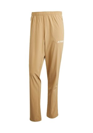 Pantalones ligeros beige con cinturilla elástica, bolsillos laterales y un logo blanco en el muslo izquierdo. Textura suave y diseño de corte recto.