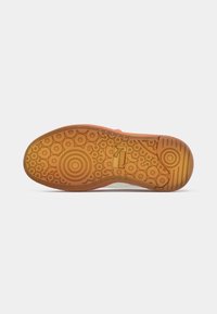 Gummisohle für Sneakers mit komplexen Kreis- und Linienmustern, in einem Pfirsich- und Beige-Farbschema. Texturiert für besseren Halt.
