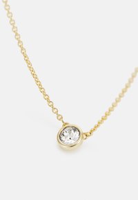 Collier en or avec une chaîne délicate, présentant un bijou rond et transparent fixé dans un sertissage à collet au centre. Texture lisse, design minimal.