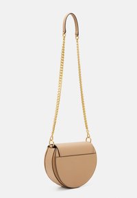 Borsa a tracolla in pelle color cuoio con forma semicircolare, tracolla a catena dorata e texture liscia. Presenta bordi neri e un design minimalista.