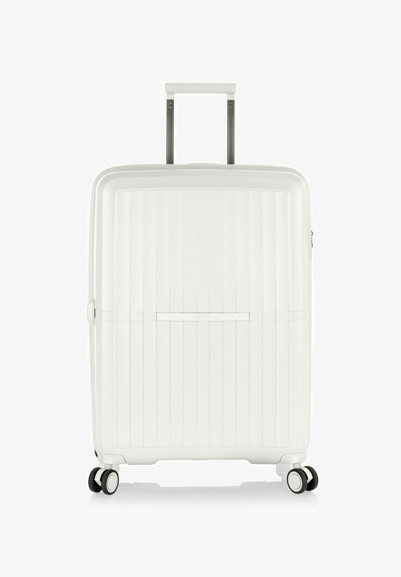 Weißer Hartschalenkoffer mit strukturiertem Rillen-Design, ausgestattet mit einem Teleskopgriff, vier schwarzen Rollen und einem Reißverschluss.