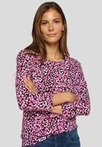 Long-sleeve top in black, pink, and white leopard print pattern; made of soft fabric with round neckline and relaxed fit.