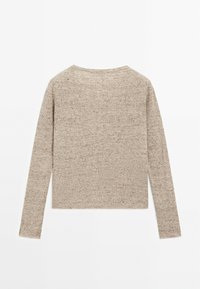 Pull en tricot beige, avec des manches longues, un col rond et une texture douce. Le tissu présente un motif côtelé subtil et fin.
