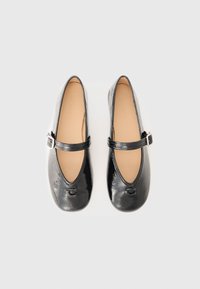 Black patent leather Mary Jane flats with a rounded toe, single adjustable strap, and a subtle logo embossed on the toe. Smooth texture.