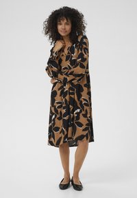 Braun und schwarzes Blumenkleid mit langen Ärmeln, V-Ausschnitt und fließender A-Linie. Der Stoff zeichnet sich durch ein strukturiertes Muster und einen sanften Fall aus.