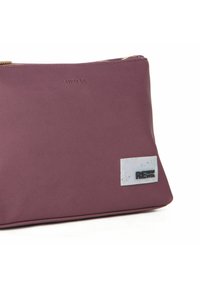 Lilla tekstureret pung med cremefarvet accentmærke, der har teksten "RENEW" i sort, lynlås lukning og glatte kanter. Lavet af holdbart materiale.