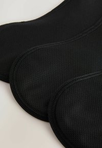 Czarne, teksturowane podkładki z tkaniny z siatkowym wzorem, o gładkich zaokrąglonych krawędziach i kontrastowym przeszyciu.