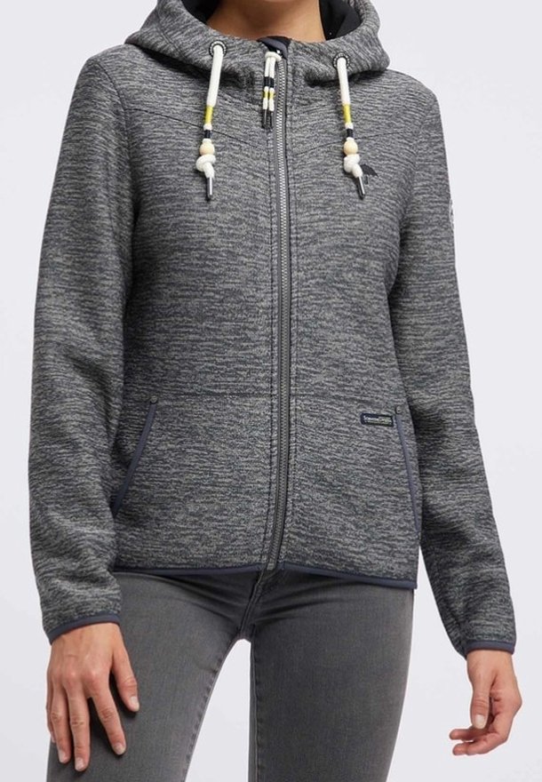 Sweat à capuche zippé gris avec un motif texturé, capuche avec cordon de serrage, deux poches avant, et des accents navy contrastants. Fabriqué en tissu doux.
