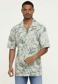 Chemise hawaïenne de couleur vert menthe, ornée de motifs floraux et de feuilles en blanc, jaune et turquoise, avec des manches courtes et un devant à boutons.