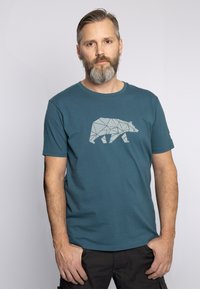 Teal katoenen t-shirt met een witte geometrische beerafbeelding op de voorkant, ronde hals en korte mouwen. Glad materiaal, casual pasvorm.