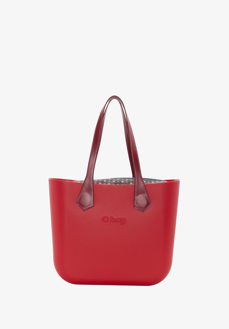 Red tote bag with smooth, rounded edges, leather handles, and a patterned interior. Features embossed logo on the front.