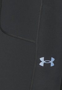 Pantaloni sportivi neri con una superficie texturizzata, logo blu a contrasto e cuciture prominenti lungo i lati. Progettati per l'abbigliamento attivo.