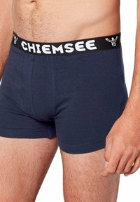 Boxer in cotone blu navy con cintura elastica nera caratterizzata dalla scritta bianca "CHIEMSEE" e un design morbido e aderente.