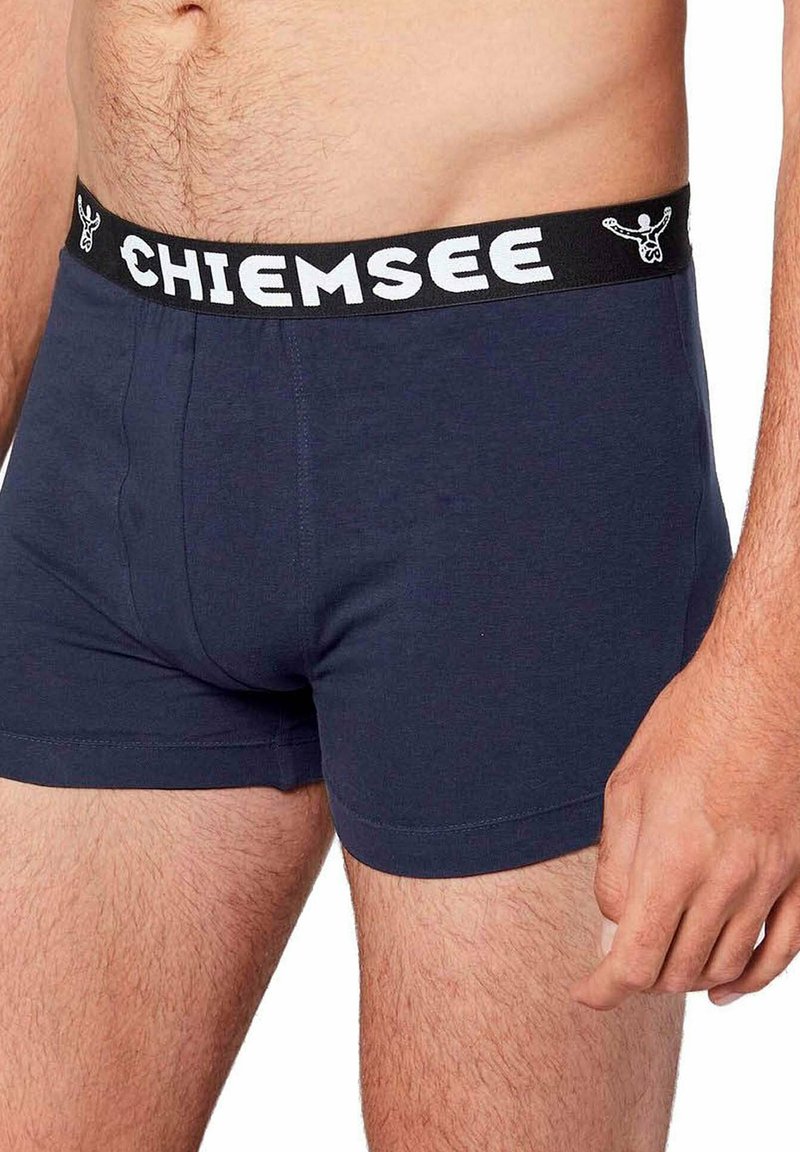Boxer in cotone blu navy con cintura elastica nera caratterizzata dalla scritta bianca "CHIEMSEE" e un design morbido e aderente.