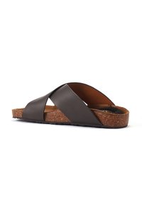 Brown crossover slide sandal made of smooth leather with a textured cork sole and rubber grip, featuring soft suede lining.