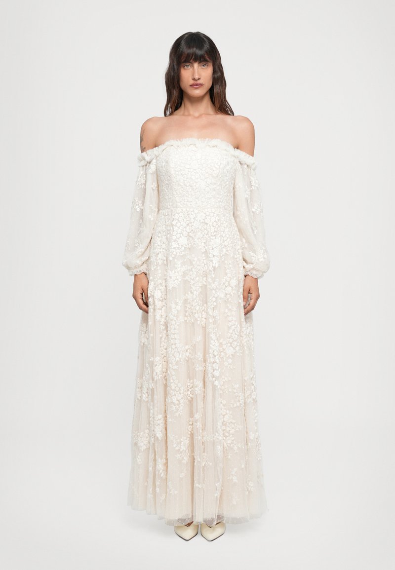 Vestido de novia off-the-shoulder en crema con mangas largas transparentes, adornado con bordados florales y falda acampanada, con un acabado de silueta fluida.