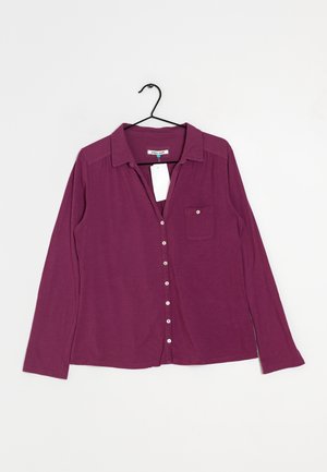 Long-sleeve purple blouse with a button-up front, collar, single chest pocket, and soft texture, displayed on a hanger.