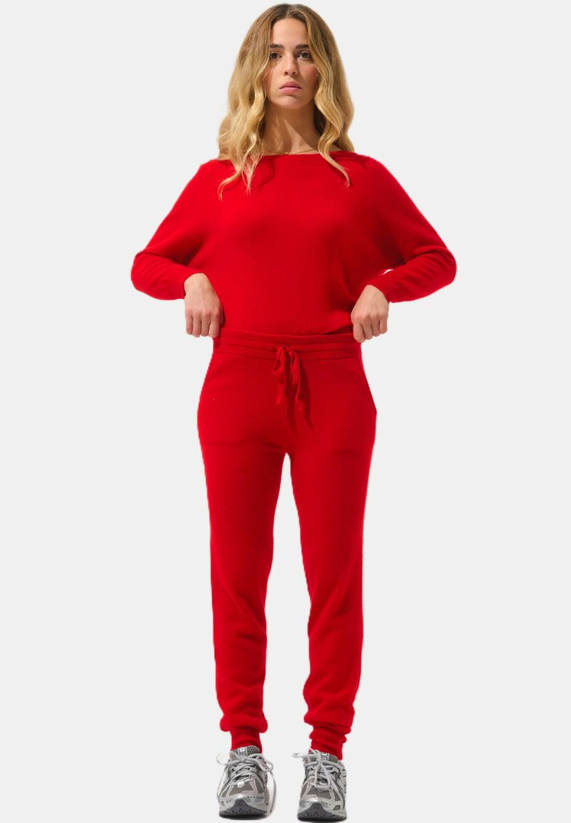 Rode loungewearset bestaande uit een lange mouw top en aansluitende broek met een trekkoord in de taille. Zachte textuur, ontspannen pasvorm en een gladde afwerking.